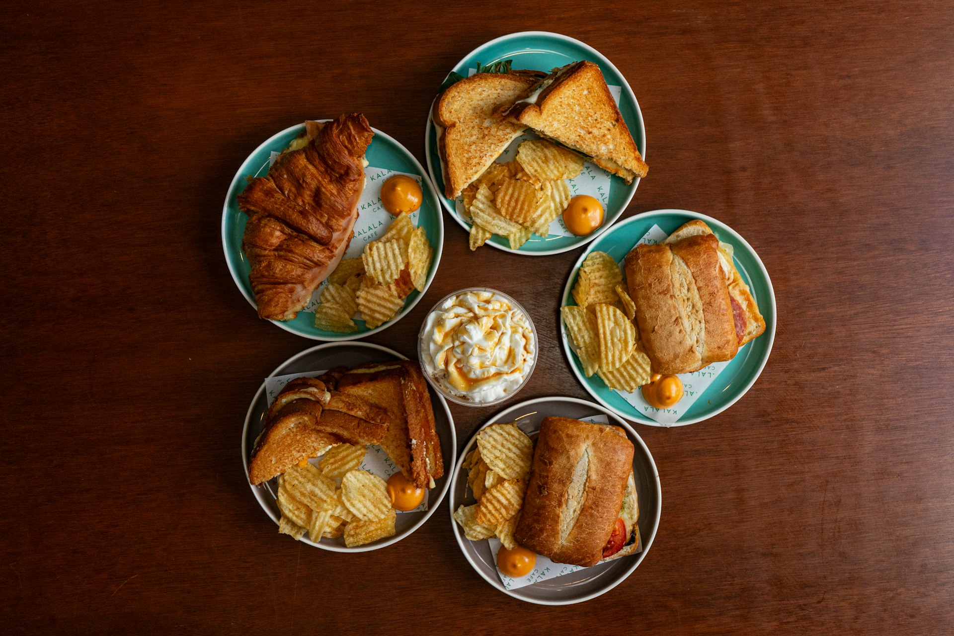 A wooden table topped with four plates of food
